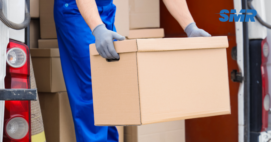 man with a van Grays cheap movers lifting sofa carefully inside a home