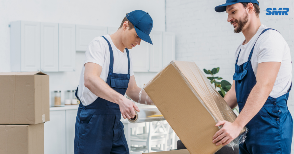 man with a van Greenwich cheap movers lifting sofa carefully inside a home