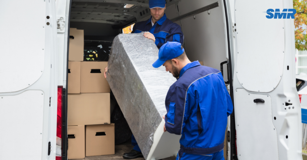 two movers loading sofa into van in Datford
