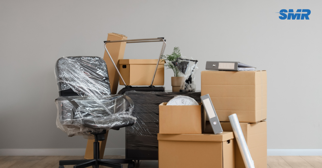Office removals team in Beckton unloading business equipment from a van.
