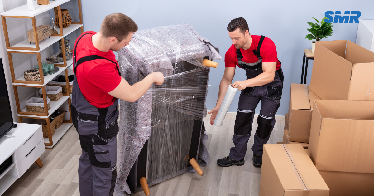 Flat removals Peckham movers carrying sofa into apartment building