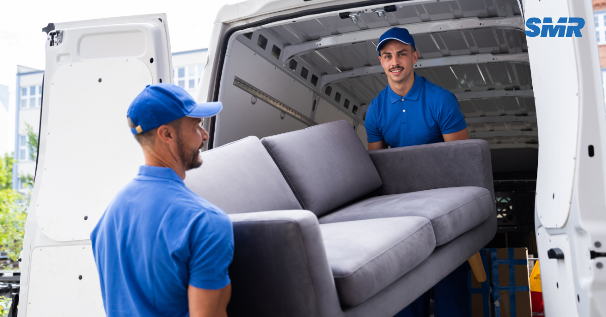 Mover transporting furniture with a Sureman Removals van in North Finchley