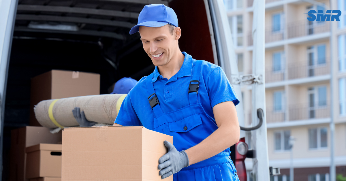Professional movers loading boxes into a Sureman Removals van in Kensal Green