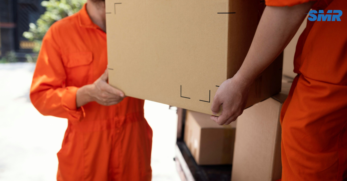 Two professional movers carrying a sofa into a home in Kentish.