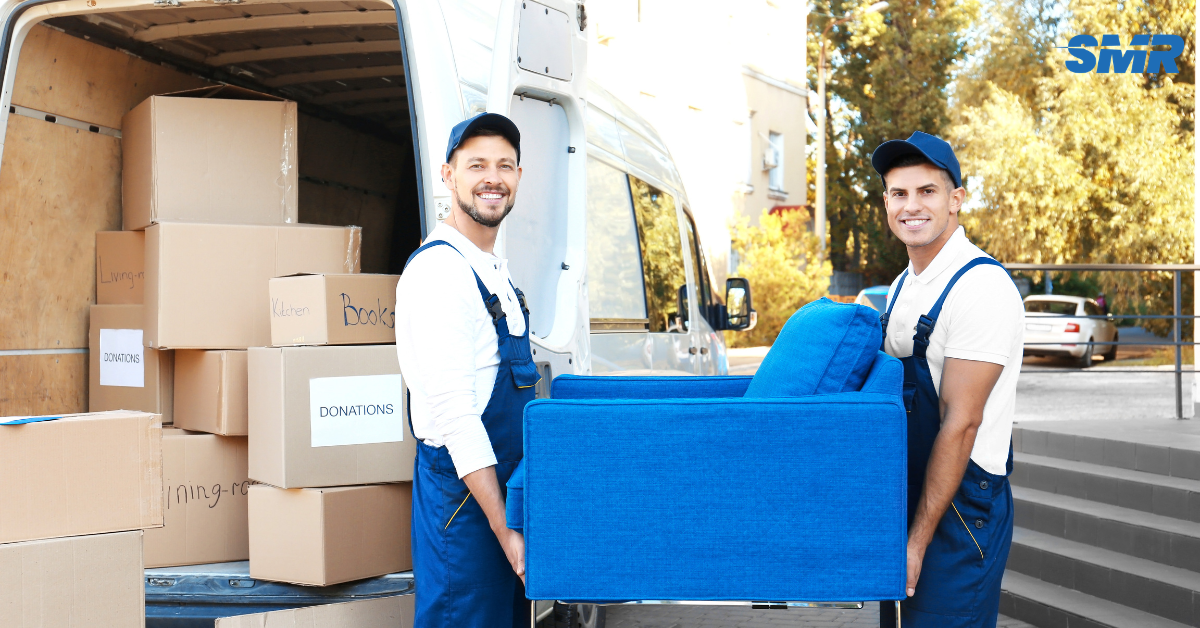 Two movers carrying a sofa into a house during a Kentish removal.