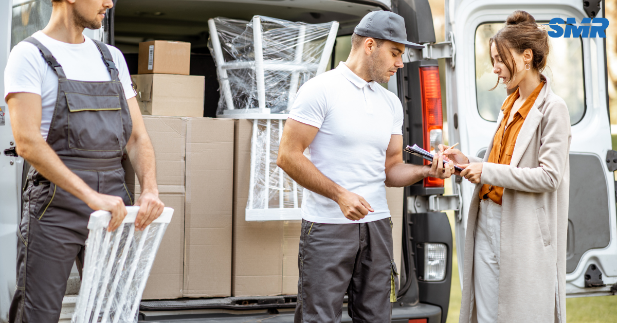 Two professional movers carrying a sofa during a house removal in Kidbrooke