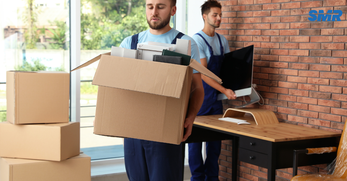 Two movers carrying a sofa into a property during a house removal in Kidbrooke