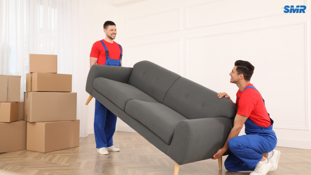 Movers transporting a sofa and flat-pack furniture
