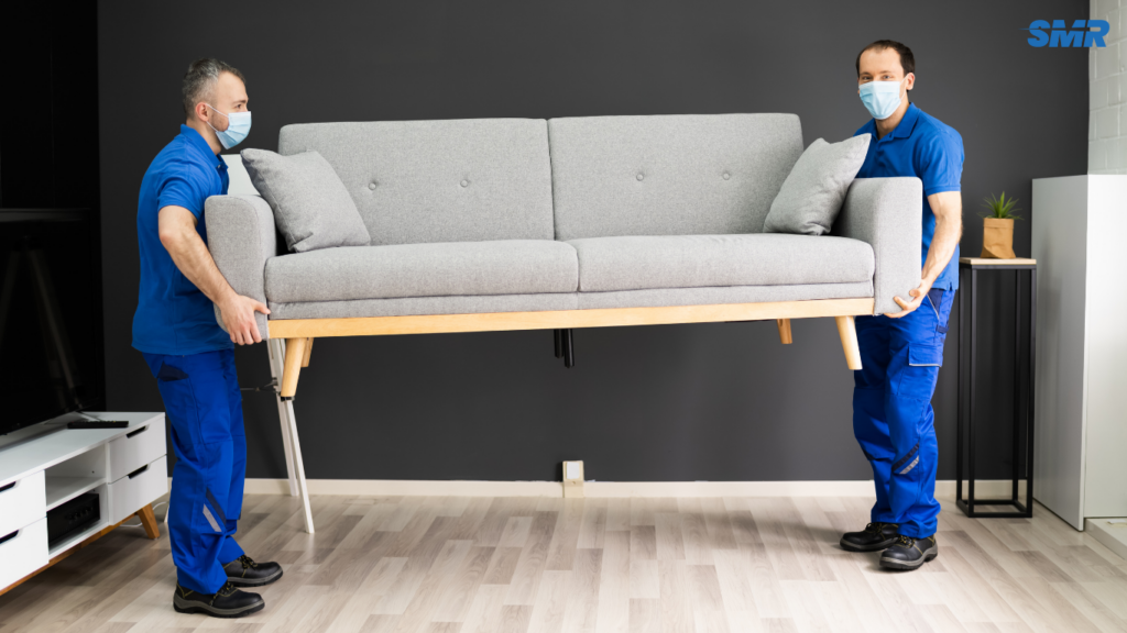 Movers transporting a sofa and flat-pack furniture