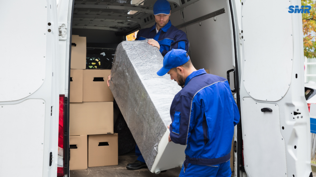Movers carrying office furniture and equipment